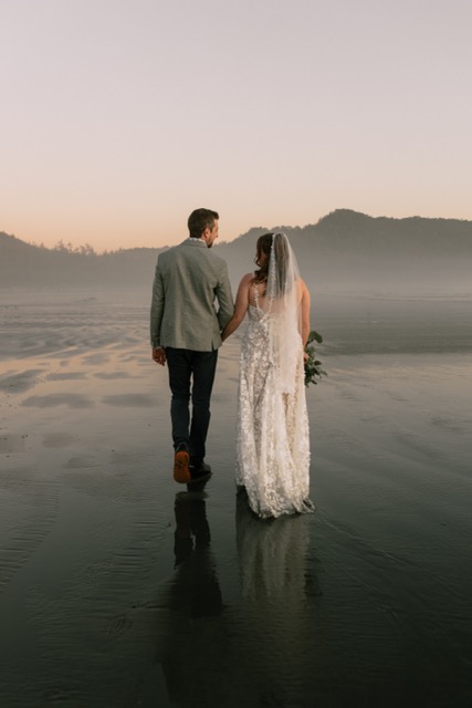 Couple walking hand in hand along a misty beach